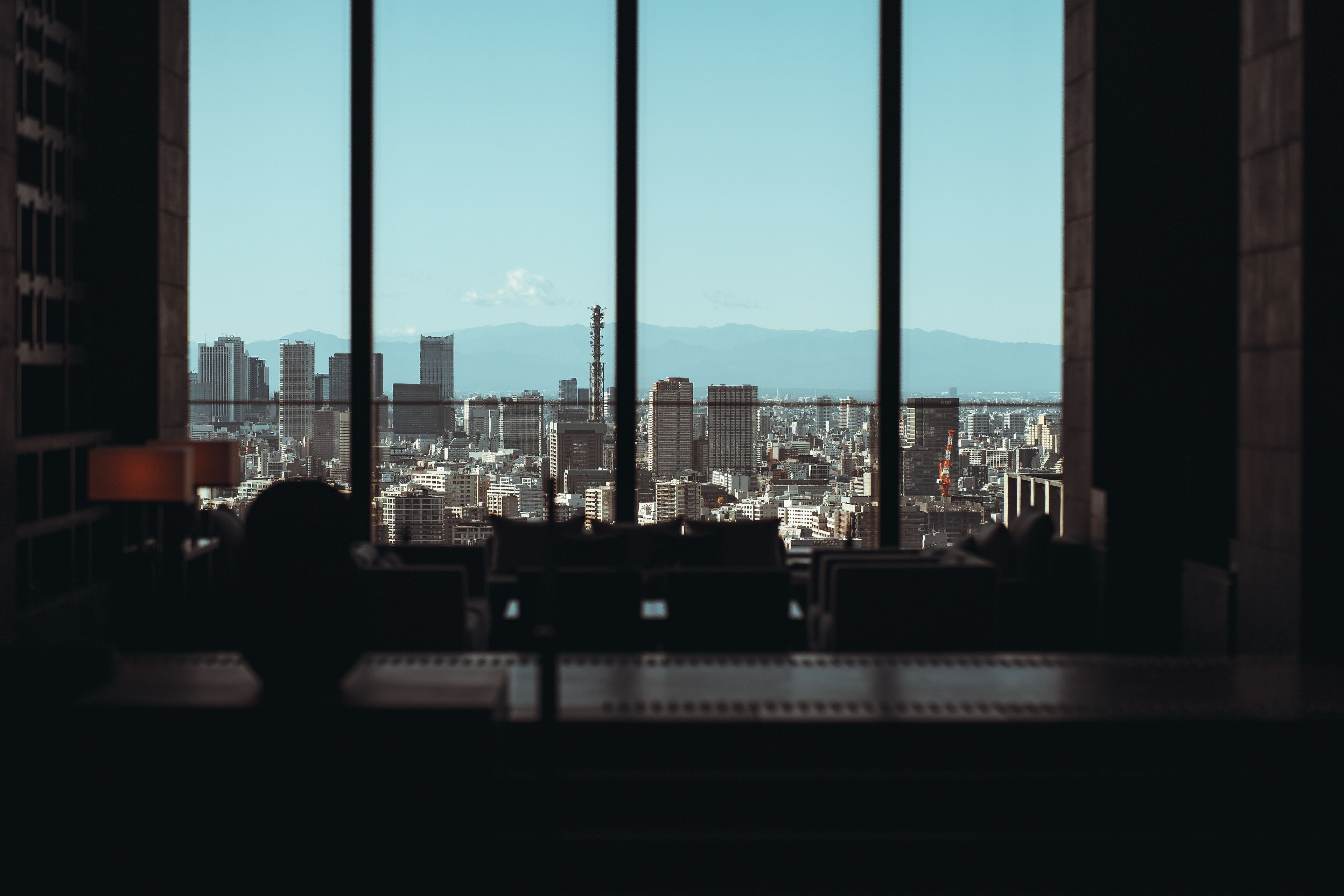 Office in half-light, a tall window opening onto the city.